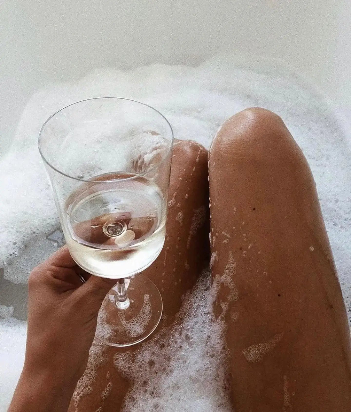 Tanned Girl in Bathtub holding wine